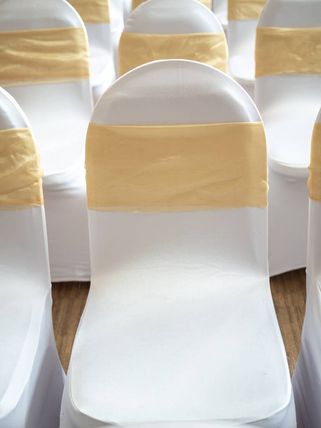Όμορφες λευκές και καθαρές καρέκλες γάμου διακοσμημένες με χρυσό πλευρό - Φωτογραφία, εικόνα