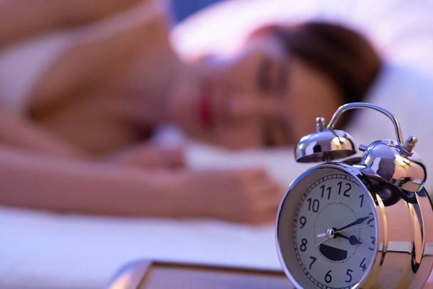 Ασιάτης/ισσα γυναίκα ύπνος με ρολόι - Φωτογραφία, εικόνα
