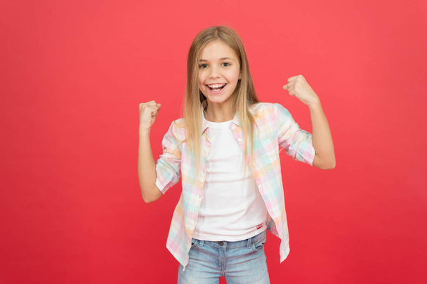Feeling awesome. Happy childhood. Girl child smiling face expression on red background. Positive emotions concept. Happy childrens day. Being happy every day. Schoolgirl casual style emotional kid - Foto, Imagem