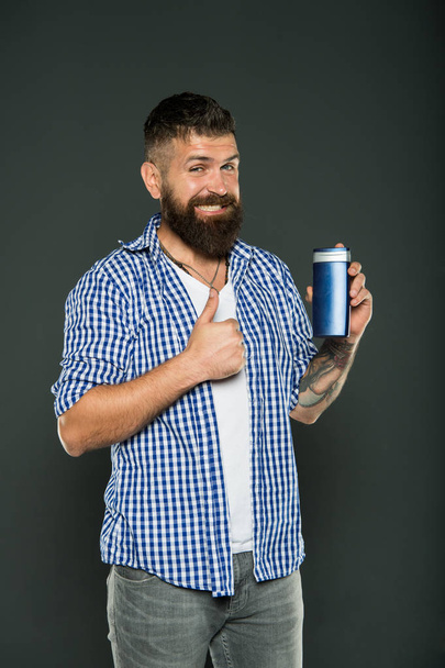 The best care ever. Bearded man showing thumbs up for hair care product on grey background. Happy hipster liking his shampoo or gel for personal care. Skin and body care - Φωτογραφία, εικόνα