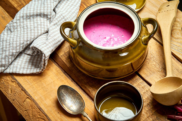 Old vase with  cold beetroot soup and spoon on rustic wooden table - Photo, Image