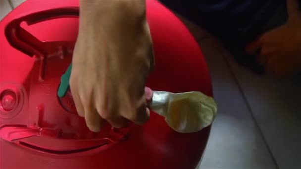 Las manos masculinas inflan globo usando tanque de helio
. - Metraje, vídeo