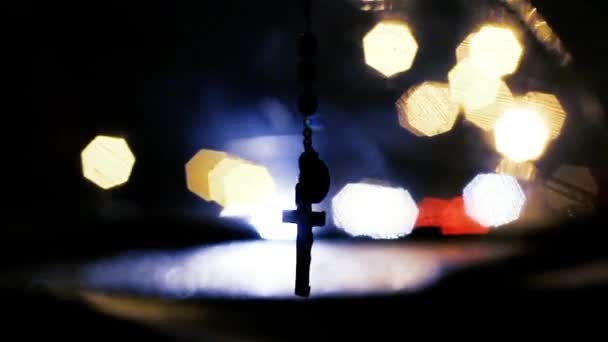 Rosenkranz hängt nachts am Rückspiegel des Autos. - Filmmaterial, Video