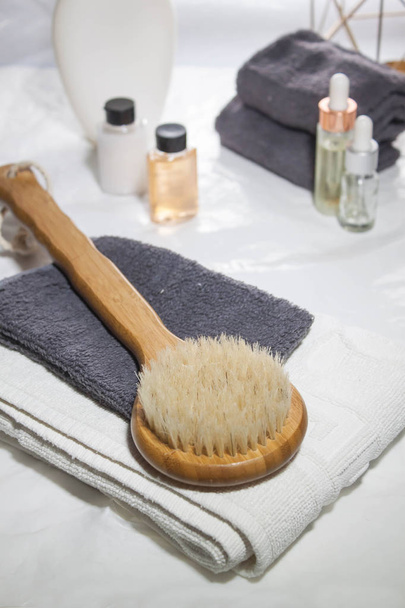 Round brush with a long handle for dry massage. Various spa objects on white background. Body and skin care. Beauty care concept. Anticellulite massage. - 写真・画像