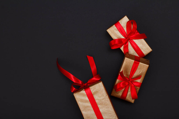 Cajas de regalo con cintas rojas sobre fondo negro
. - Foto, imagen