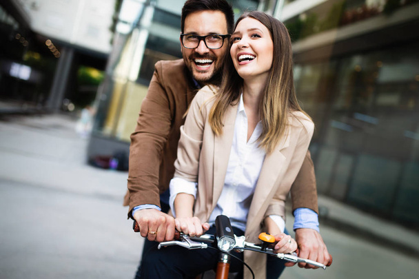 Jovem casal feliz se divertindo na cidade e andar de bicicleta - Foto, Imagem
