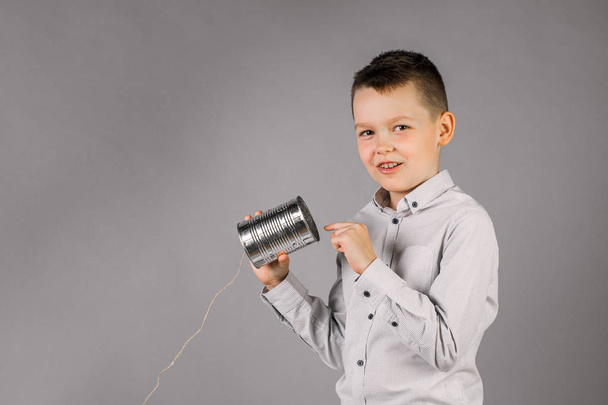 Хлопчик прислухається до цікавих гарних новин про олово Can - Фото, зображення