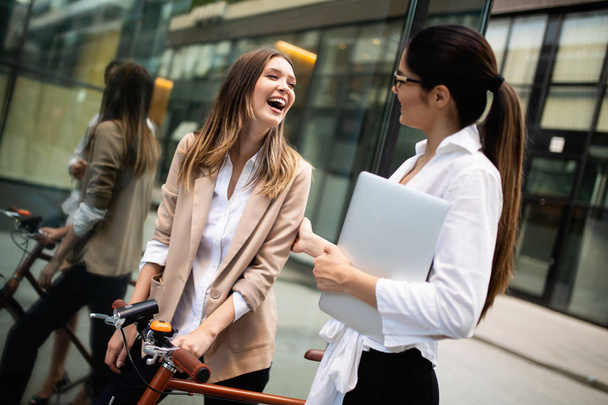 Happy business colleagues talking, smiling and walking in the city outdoor - Foto, Imagen