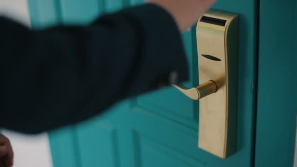 Człowiek w ciemnoniebieskim kolorze próbuje odblokować masywne turkusowe drzwi z nieodpowiednim plastikowym kluczem karty. Człowiek nie może odblokować drzwi z plastikową kartą. Zamknięcie klamki. - Materiał filmowy, wideo