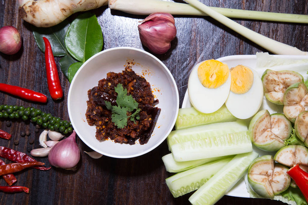 Thai chili paste Nam Prik dip served with long bean, cucumber, white turmeric, boiled egg, eggplant and carrot, Thai traditional food. Selective focus - Valokuva, kuva