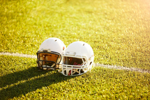 Photo of two football helmets on stadium - Φωτογραφία, εικόνα