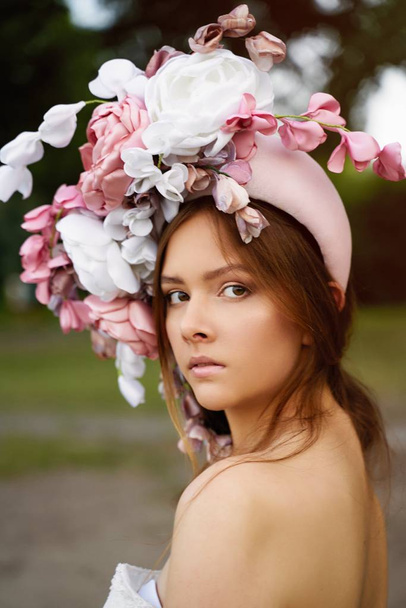 Gorgeous young woman in outstanding headdress posing  - Фото, изображение