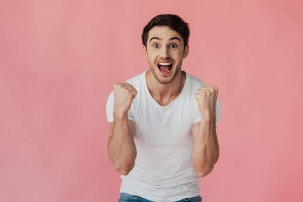 front view of excited muscular man in white t-shirt showing yes gesture isolated on pink - Foto, Imagen