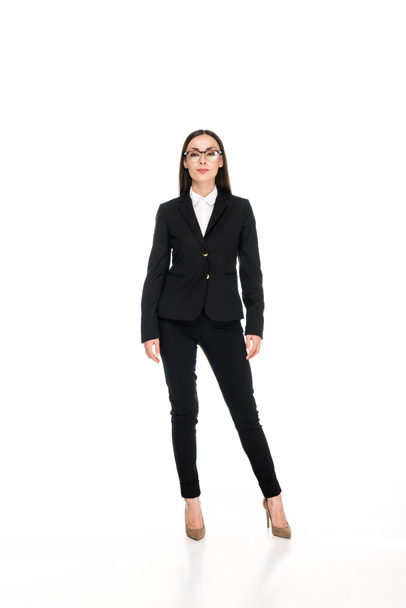 vista completa de mujer de negocios confiada en traje negro con brazos cruzados aislados en blanco
 - Foto, Imagen