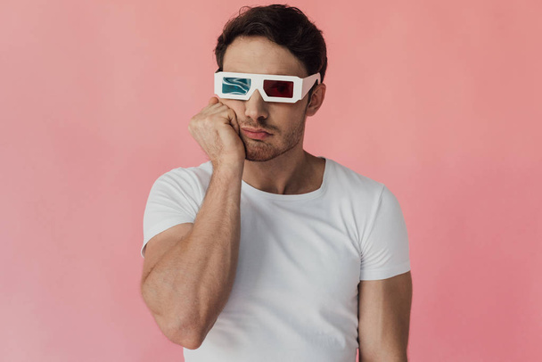 задумчивый мускулистый мужчина в 3D очках, поддерживающий лицо рукой, изолированной на розовом
 - Фото, изображение
