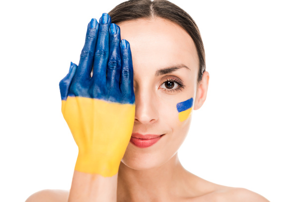 顔と白で隔離された顔と手に描かれたウクライナの旗を持つ裸の若い女性 - 写真・画像