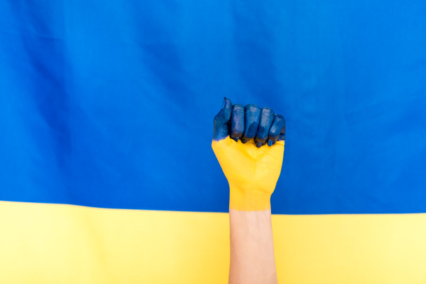 vista ritagliata di mano dipinta su sfondo bandiera ucraina
 - Foto, immagini