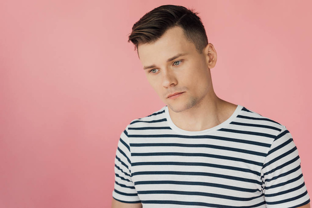 pensive man in striped t-shirt looking away isolated on pink - Photo, Image