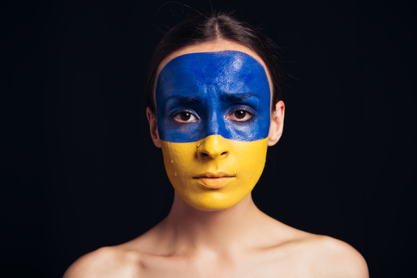 naked young woman with painted Ukrainian flag on face isolated on black - Fotoğraf, Görsel