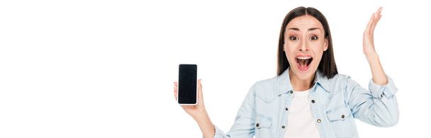 збуджена молода жінка, що показує смартфон з порожнім екраном ізольовано на білому, панорамний знімок
 - Фото, зображення