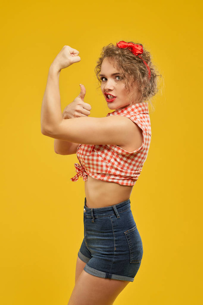 Strong girl in stylish clothes showing thumb up. - Valokuva, kuva