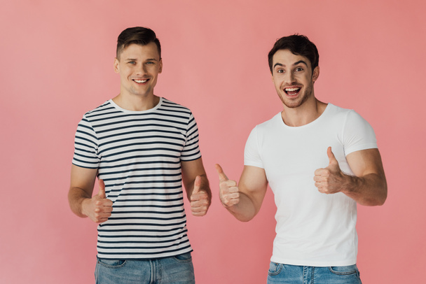 vue de face de deux amis excités en t-shirts montrant pouces isolés sur rose
 - Photo, image