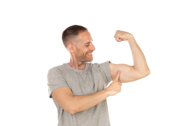 Handsome man showing his bicep isolated on a white background - Valokuva, kuva