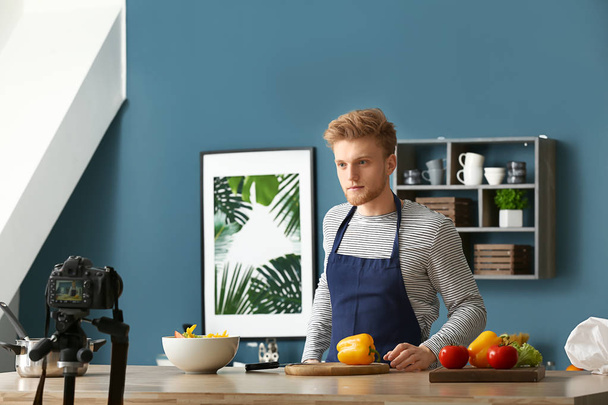 junger männlicher Food-Blogger nimmt Video in Küche auf - Foto, Bild