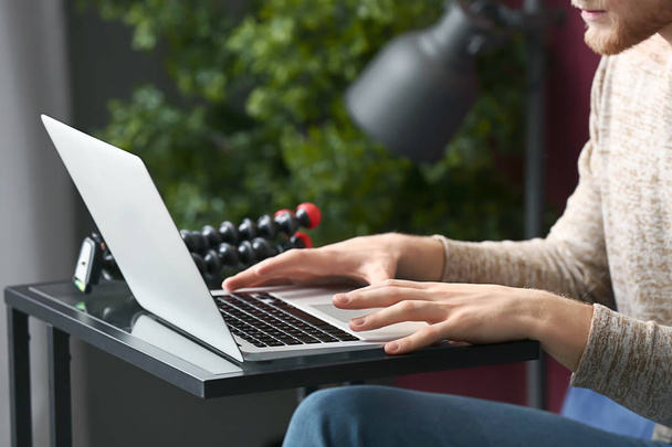 молодой человек с помощью современного ноутбука за столом
 - Фото, изображение
