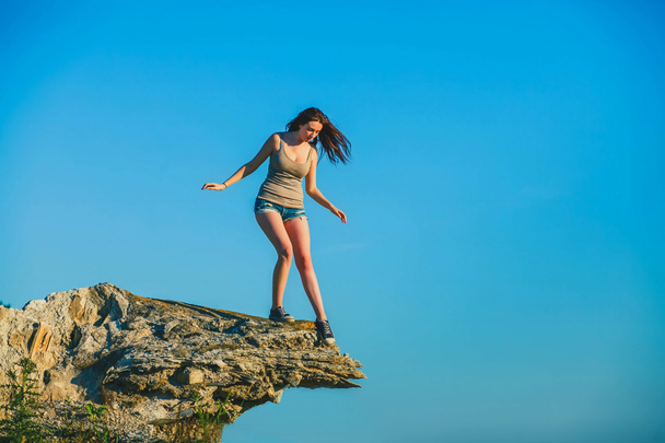 acrophobia γυναίκα ψηλά ορθώνεται ένα βράχο άκρη βράχου και είναι - Φωτογραφία, εικόνα