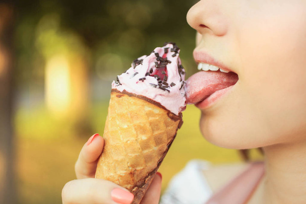 Κορίτσι γλείφει τη γλώσσα της αναζωογονητικό ροζ παγωτό - Φωτογραφία, εικόνα