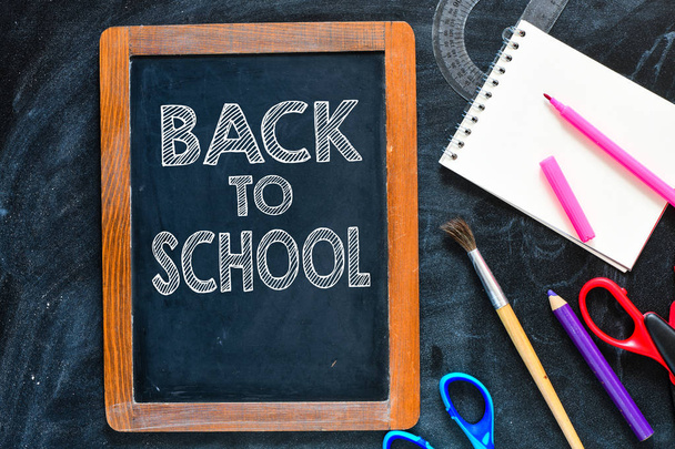Back to school written on a chalk board, school accessories - Photo, Image