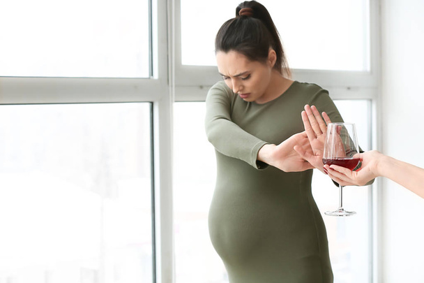 Pregnant woman rejecting alcohol near window - Zdjęcie, obraz
