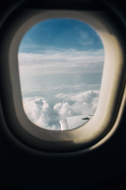 Airplane window with clouds and sky in the evening - Фото, зображення