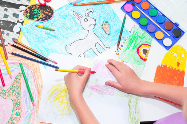 χέρια του παιδιού. Ένα μικρό αριστερόχειρας παιδί που ζωγραφίζει με μολύβια. Κορυφαία άποψη, εκπαίδευση ζωγραφική, σχέδιο αντίληψη. - Φωτογραφία, εικόνα
