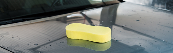 panoramic shot of yellow sponge on clean and wet grey automobile  - Photo, Image