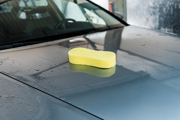 κίτρινο σφουγγάρι σε καθαρό και βρεγμένο γκρίζο αυτοκίνητο  - Φωτογραφία, εικόνα