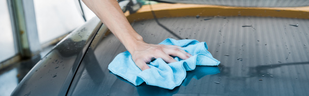 plano panorámico del hombre limpieza coche mojado con trapo azul
  - Foto, imagen