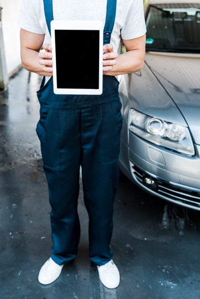 vista ritagliata di pulitore auto tenendo tablet digitale con schermo vuoto
  - Foto, immagini