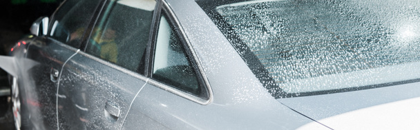 panoramiczny strzał szary Auto z białą pianką w myjni samochodowej  - Zdjęcie, obraz