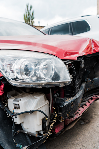 επιλεκτική εστίαση του κατεστραμμένου κόκκινου οχήματος μετά από αυτοκινητιστικό δυστύχημα  - Φωτογραφία, εικόνα