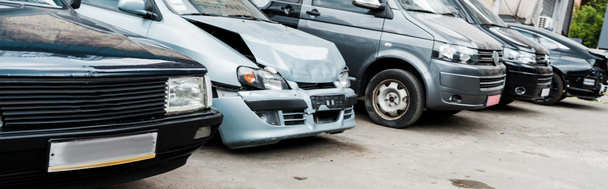Panoramaaufnahme eines beschädigten Fahrzeugs nach einem Autounfall in der Nähe moderner Autos - Foto, Bild