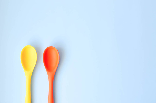Fletley from multi-colored spoons on a blue background. - Photo, Image