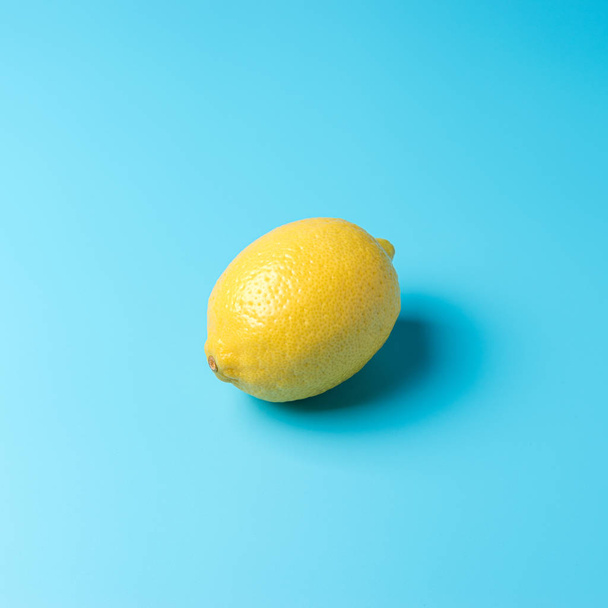 Fresh lemon on blue background. Minimal food concept. - Foto, afbeelding
