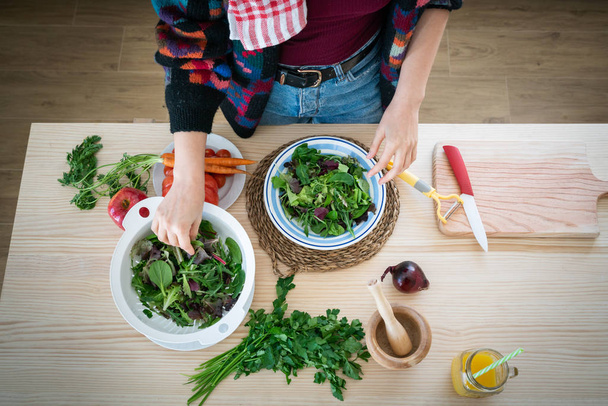руки женщины, готовящей овощи во время приготовления здорового салата на кухне
 - Фото, изображение
