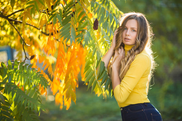 秋の背景に屋外で若い魅力的なブロンドの女性。美しいスタイリッシュな女性の秋の肖像画. - 写真・画像