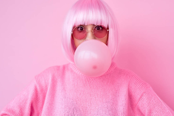 Young woman in pink outfit blowing gum - Foto, Bild