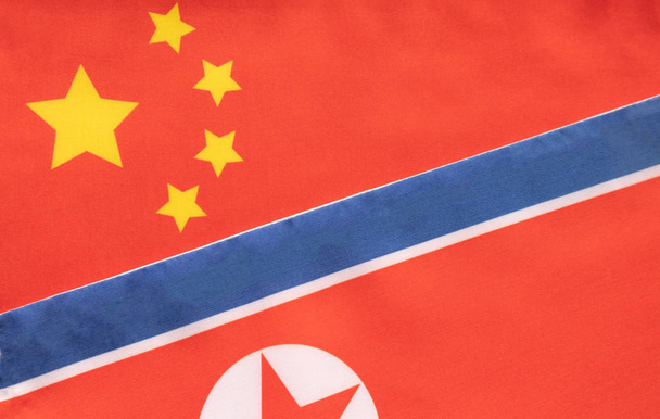 A két ország közötti kétoldalú kapcsolat fogalma két zászlóval: Kína és Észak-Korea - Fotó, kép