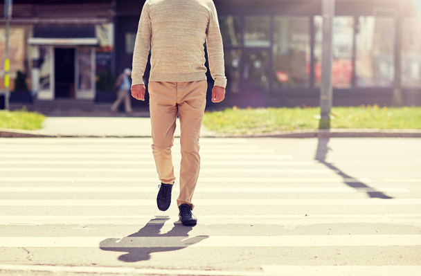 senior man walking along city crosswalk - Foto, Bild