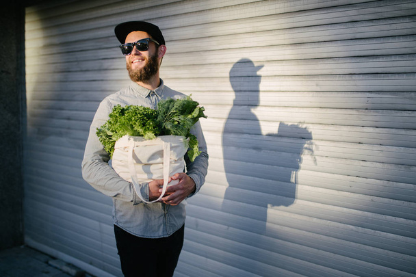 Man holding an eco bag filled with grocery. Vegetables and fruits. Ecology concept environment protection. - Фото, изображение